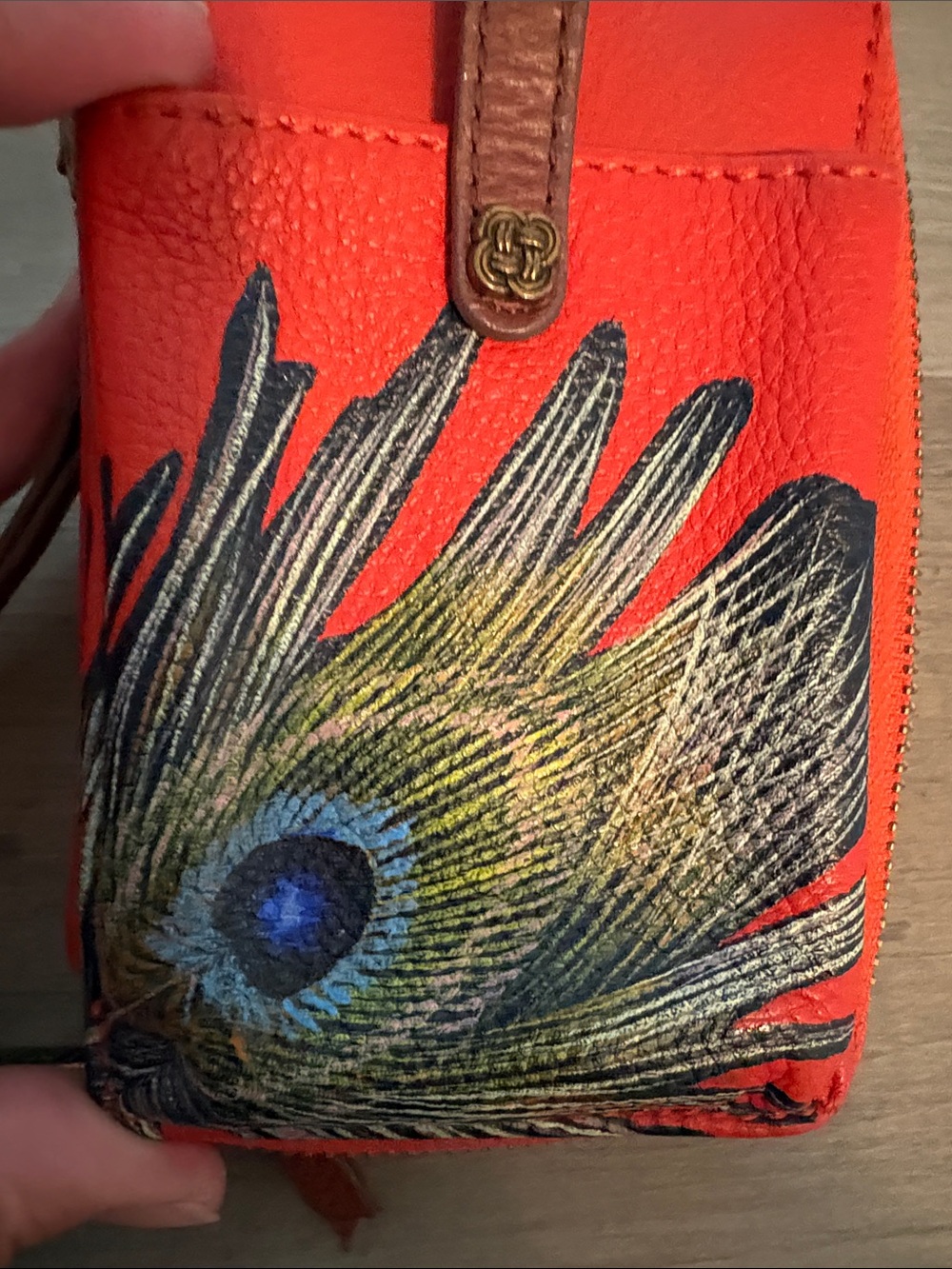 orange leather Elliott Lucca wristlet features a hand-painted peacock feather - Picture 2 of 8